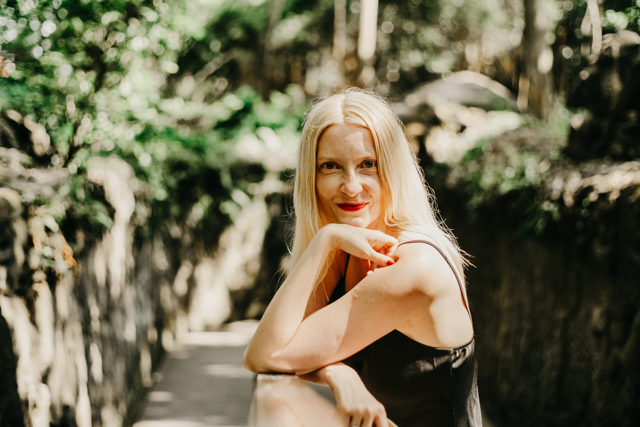 blonde woman smiling in the jungle sun