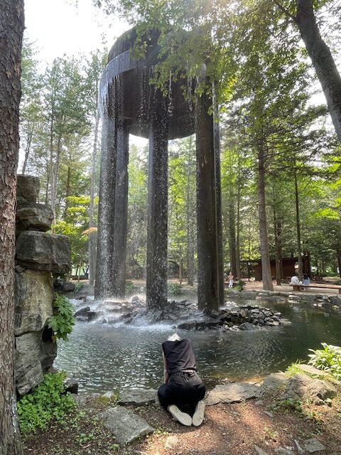 woman near a waterfall sculpture